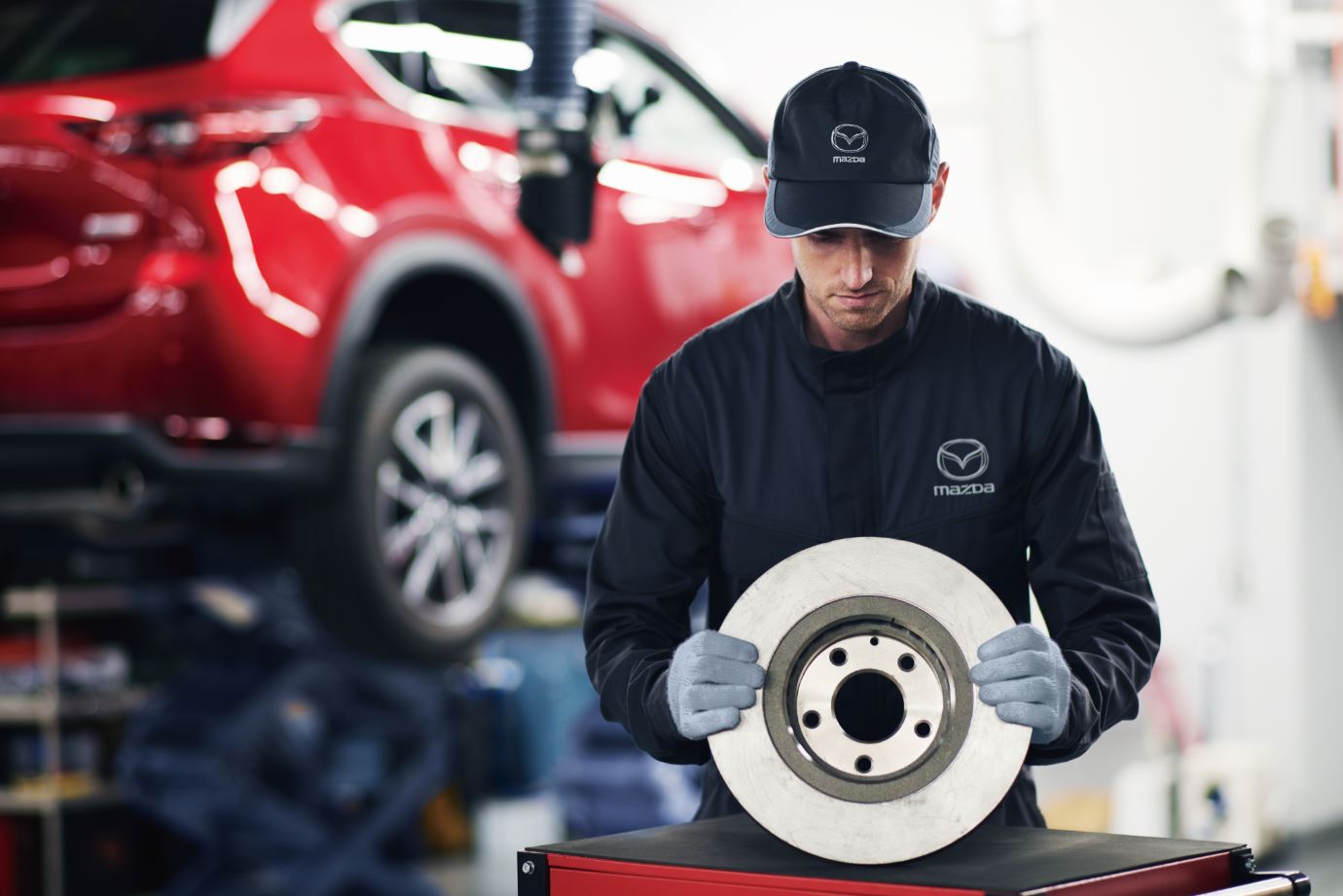 Mazda technician holding a genuine brake disc